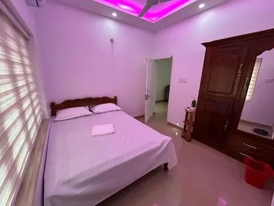 a bedroom with a white bed with a purple ceiling at Puzhayoram Homestay in Trichūr