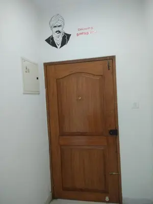 a door in a room with a sticker on the wall at Gerones Residency Serviced Apartments & Home Stays in Coimbatore