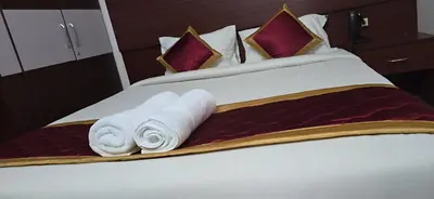 a hotel room with a bed with towels on it at PPH Living Arvind Inn in Coimbatore