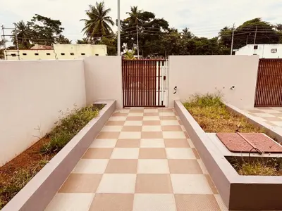 a gate in a white wall with a checkered floor at A B House in Kollegālam