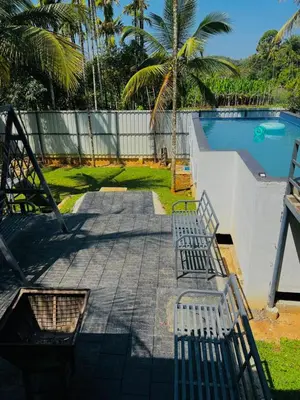 a patio with two benches next to a swimming pool at familyvillasliesure in Padinjarathara