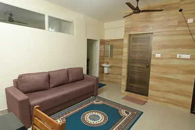 a living room with a couch and a toilet at Gokulam By Upasana in Guruvāyūr