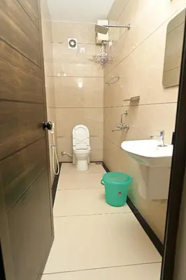 a small bathroom with a toilet and a sink at Gokulam By Upasana in Guruvāyūr