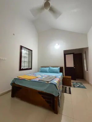 a bedroom with a bed and a ceiling fan at Dream House Near IIM Kozhikode & NIT Calicut in Kozhikode