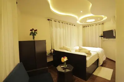 a hotel room with a bed and a couch at Blue Bell Resort in Periya