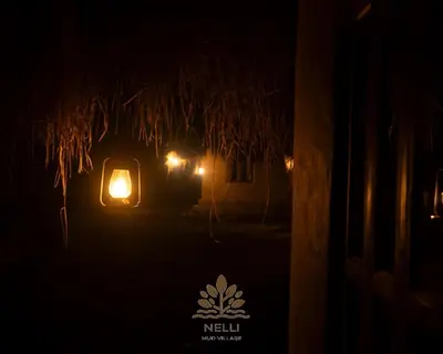 a night view of a house with a light in the dark at Nelli Mud Village in Thirunelli