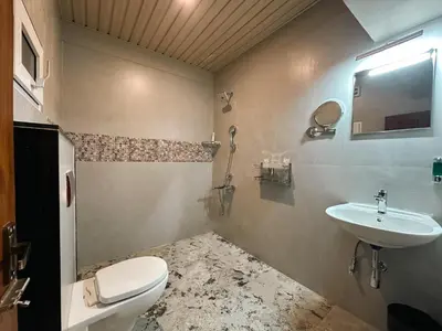 a bathroom with a toilet and a sink at The Humming Bird A Stay Chapter in Ooty