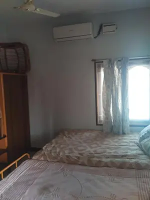 a bedroom with a bed and a window at Kumarasamy House in Tiruchengodu