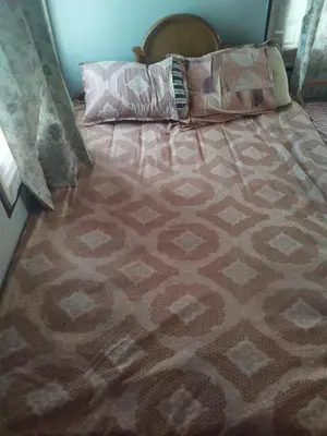 a bed with two pillows on top of it at Kumarasamy House in Tiruchengodu