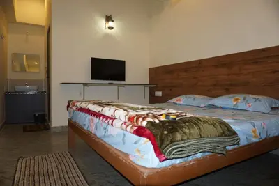 a bedroom with a large bed with a tv on the wall at Signature by Rayhan in Vālpārai