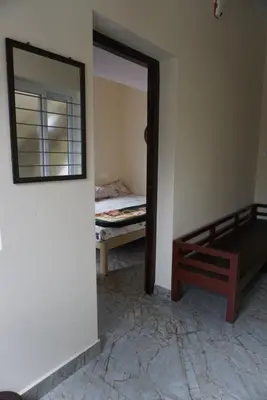 a bedroom with a mirror and a bed in a room at Signature by Rayhan in Vālpārai