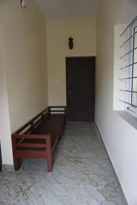 a room with a wooden bed and a door at Signature by Rayhan in Vālpārai