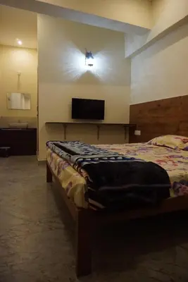 a bedroom with a bed and a flat screen tv at Signature by Rayhan in Vālpārai