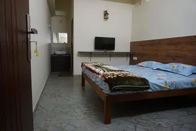a bedroom with a bed and a television in it at Signature by Rayhan in Vālpārai