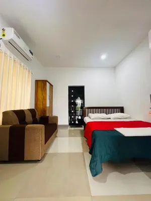 a bedroom with a bed and a couch in it at 7FORT HOMESTAY Athirappilly in Athirappilly