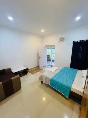 a bedroom with a bed and a couch in it at 7FORT HOMESTAY Athirappilly in Athirappilly