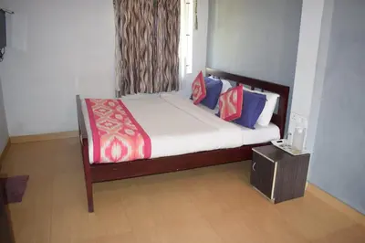 a bedroom with a large bed with colorful pillows at Mass villa in Ooty
