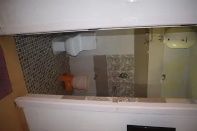 a reflection of a bathroom with a toilet in a mirror at Mass villa in Ooty