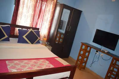 a bedroom with a bed and a flat screen tv at Mass villa in Ooty