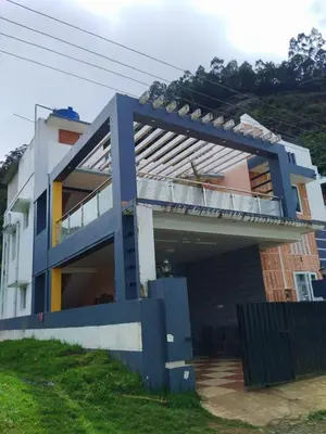 a blue and white house with a balcony at Mass villa in Ooty
