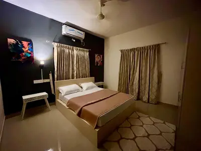 a bedroom with a bed and a tv on the wall at Krishnakripa - Luxury Private Villa Near Guruvayoor Temple in Guruvāyūr