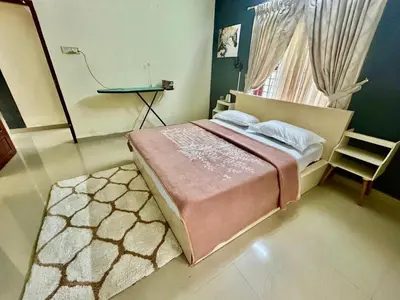 a bedroom with a bed and a window and a chair at Krishnakripa - Luxury Private Villa Near Guruvayoor Temple in Guruvāyūr