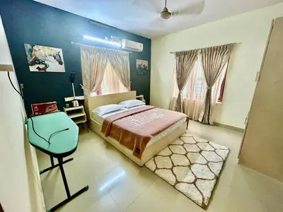 a bedroom with a bed and a chair in it at Krishnakripa - Luxury Private Villa Near Guruvayoor Temple in Guruvāyūr