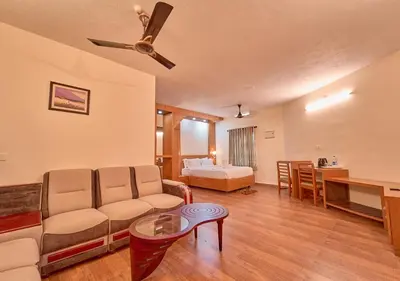 a living room with a couch and a bed at Ushasree Wayanad Premium Pool Resort by VOYE HOMES in Ambalavayal