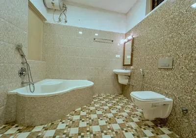 a bathroom with a tub and a toilet and a sink at Ushasree Wayanad Premium Pool Resort by VOYE HOMES in Ambalavayal