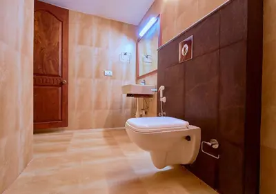 a bathroom with a white toilet in a room at Ushasree Wayanad Premium Pool Resort by VOYE HOMES in Ambalavayal