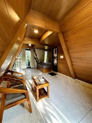 a large room with a wooden ceiling and a table at Wild Castle Wayanad in Pulpally