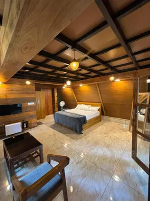 a bedroom with a bed and a table and a chair at Wild Castle Wayanad in Pulpally