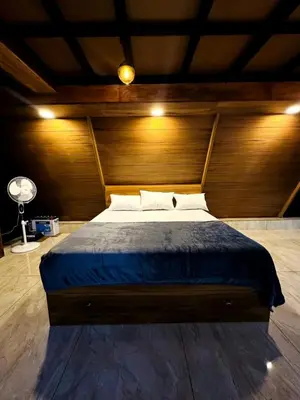a bedroom with a large bed with a wooden wall at Wild Castle Wayanad in Pulpally