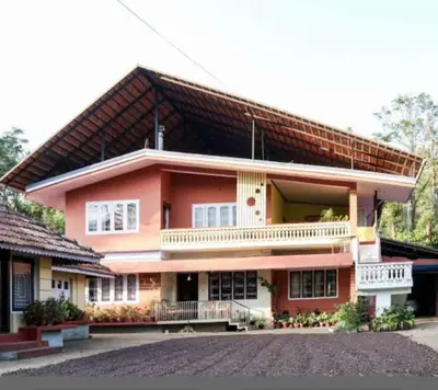 a large pink house with a roof at Coorg Naladi holidays in Kakkabe