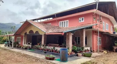 a house with a pink house at Coorg Naladi holidays in Kakkabe