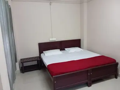 a bedroom with a large bed with a red blanket at Misty Square Residency in Kalpetta