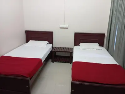 two beds sitting next to each other in a room at Misty Square Residency in Kalpetta