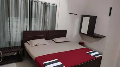 a bedroom with a bed with a mirror and a window at Misty Square Residency in Kalpetta