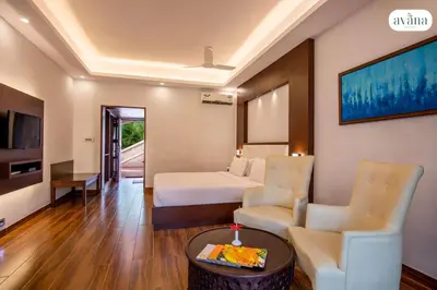 a hotel room with a bed and a table and chairs at Avana Resort in Mettuppālaiyam