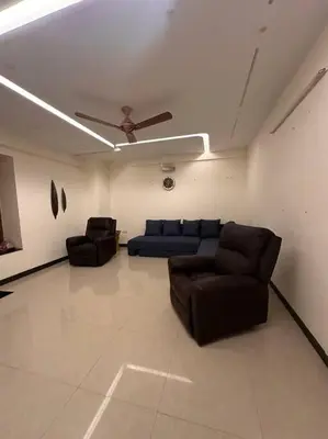 a living room with two couches and a ceiling fan at Aalayam, Villament & private pool in Mysore