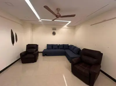 a living room with a blue couch and two chairs at Aalayam, Villament & private pool in Mysore