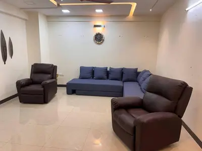 a living room with a blue couch and two chairs at Aalayam, Villament & private pool in Mysore