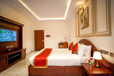 a hotel room with a bed and a television at Hotel Yathin in Mysore