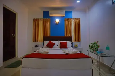 a bedroom with a large bed with red pillows at Hydel Palace Athirappilly by Bestinn Leisure in Athirappilly