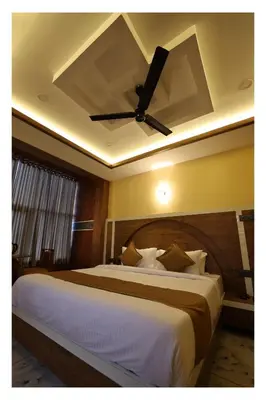 a bedroom with a large bed with a ceiling fan at Hydel Palace Athirappilly by Bestinn Leisure in Athirappilly
