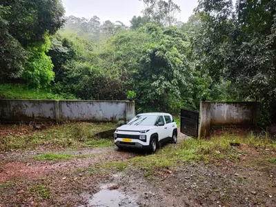 a white car parked in a dirt field at Brahmagiri Homestay Serviced Villa in Thirunelli
