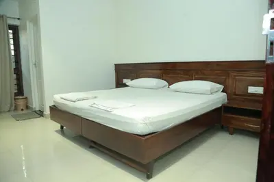a bedroom with a bed with a wooden headboard at Wariyam Heritage in Trichūr