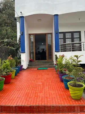 a house with colorful pots of plants in front of it at BanyanThree in Kodaikānāl