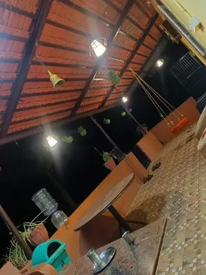 a room with a table and a bench and lights at Lilly Farm in Halgūr