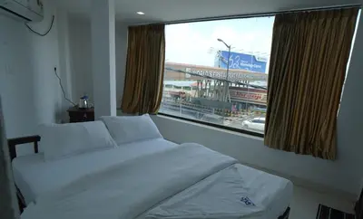 a bedroom with a bed and a large window at Port View Residency PVR in Nedumbassery